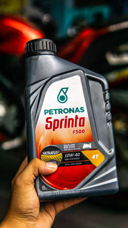151525221-bangi-malaysia-july-24-2019-hand-holding-the-petronas-sprinta-f500-oil-bottle-with-motorbike-on-back